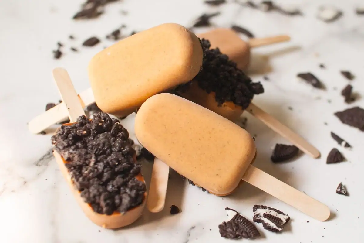 Creamy pumpkin pie popsicles coated with crunchy Oreo crumble.