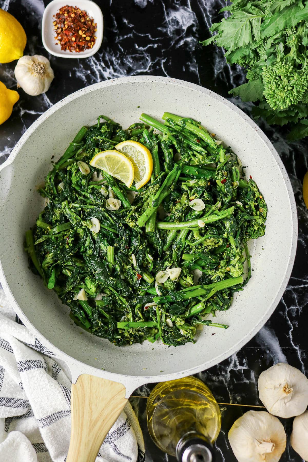 Sautéed rapini with garlic, red pepper flakes, and lemon in a skillet.
