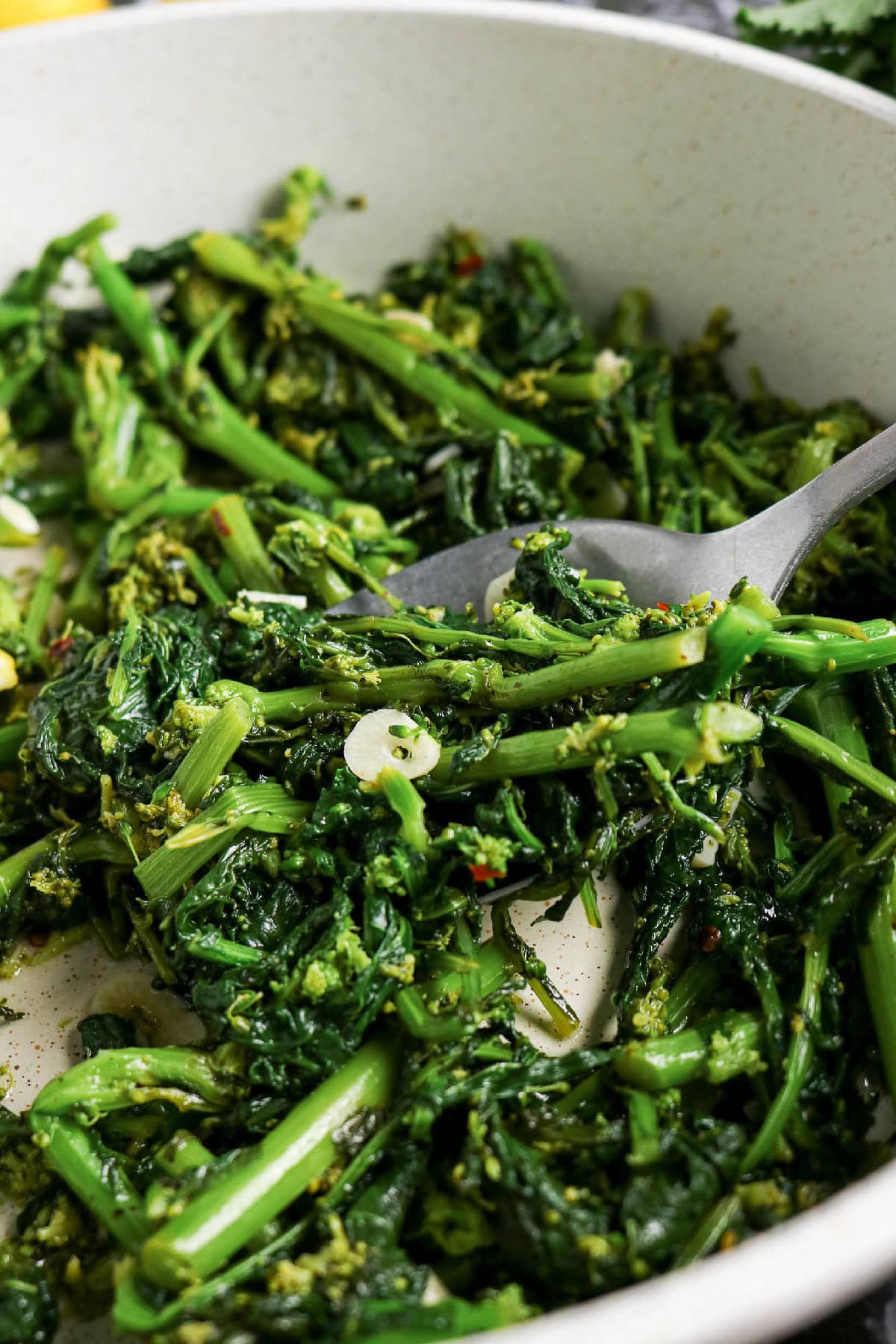 Sautéed rapini with garlic and red pepper flakes in a skillet.
