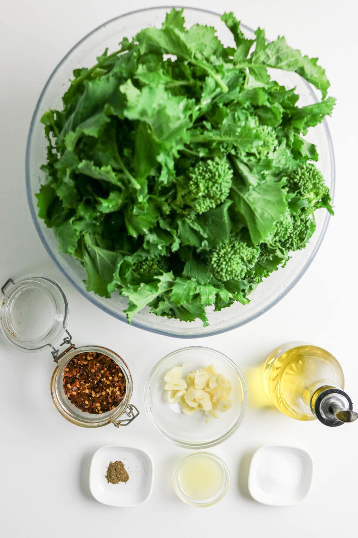 Fresh rapini with olive oil, sliced garlic, red pepper flakes, lemon juice, salt, and black pepper.