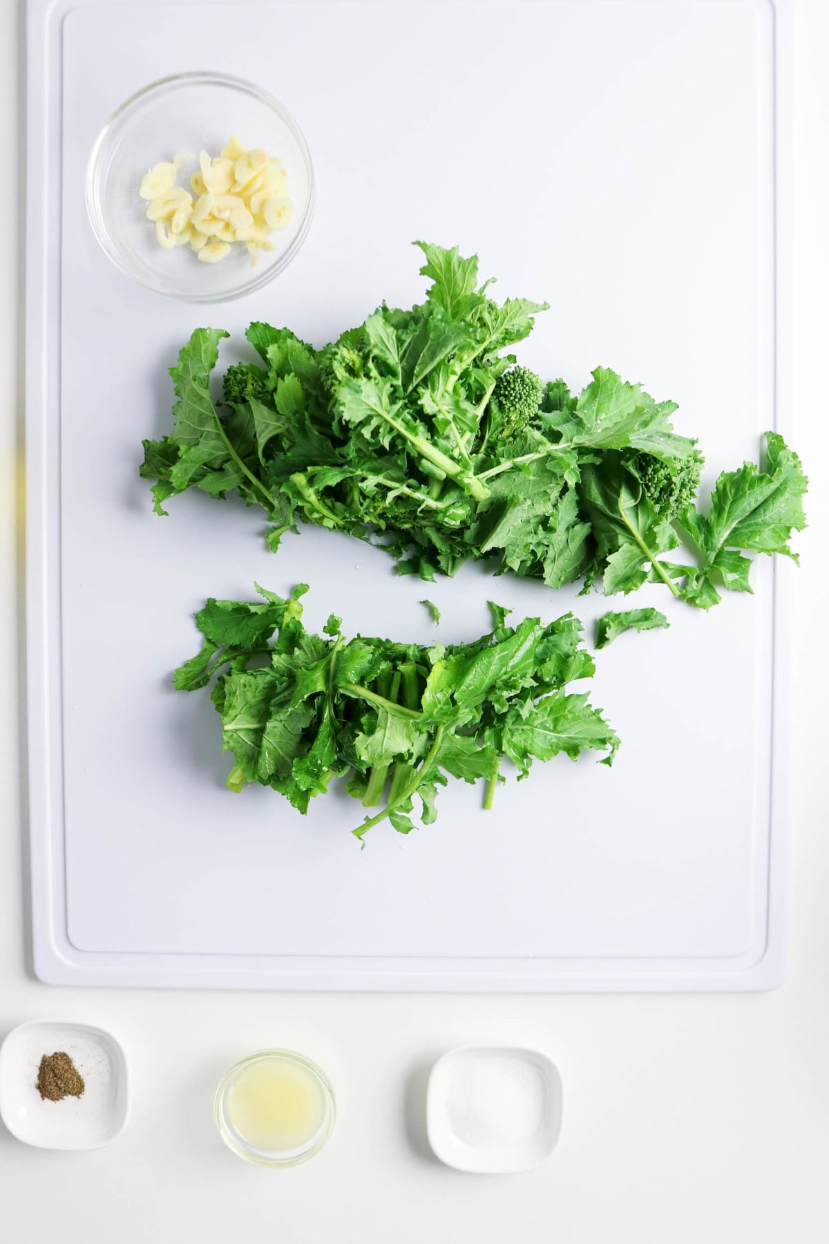 Fresh rapini trimmed and cut into pieces on a cutting board.