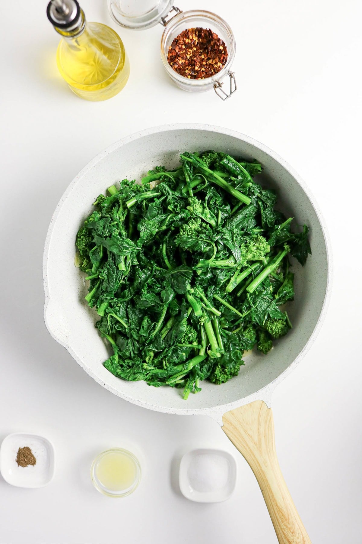 Blanched rapini added to the skillet with garlic and red pepper flakes.