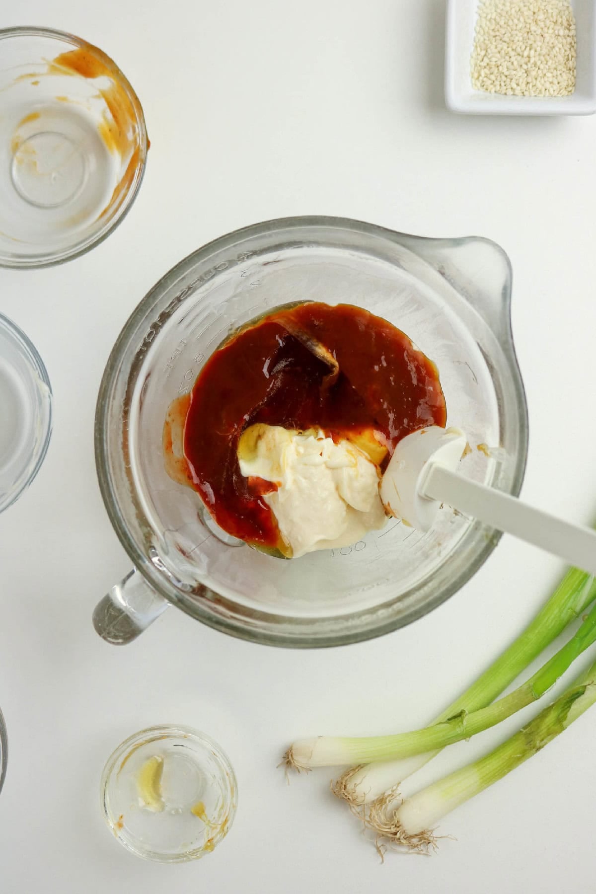 Mayonnaise, sweet chili sauce, sriracha, and honey in a mixing bowl.