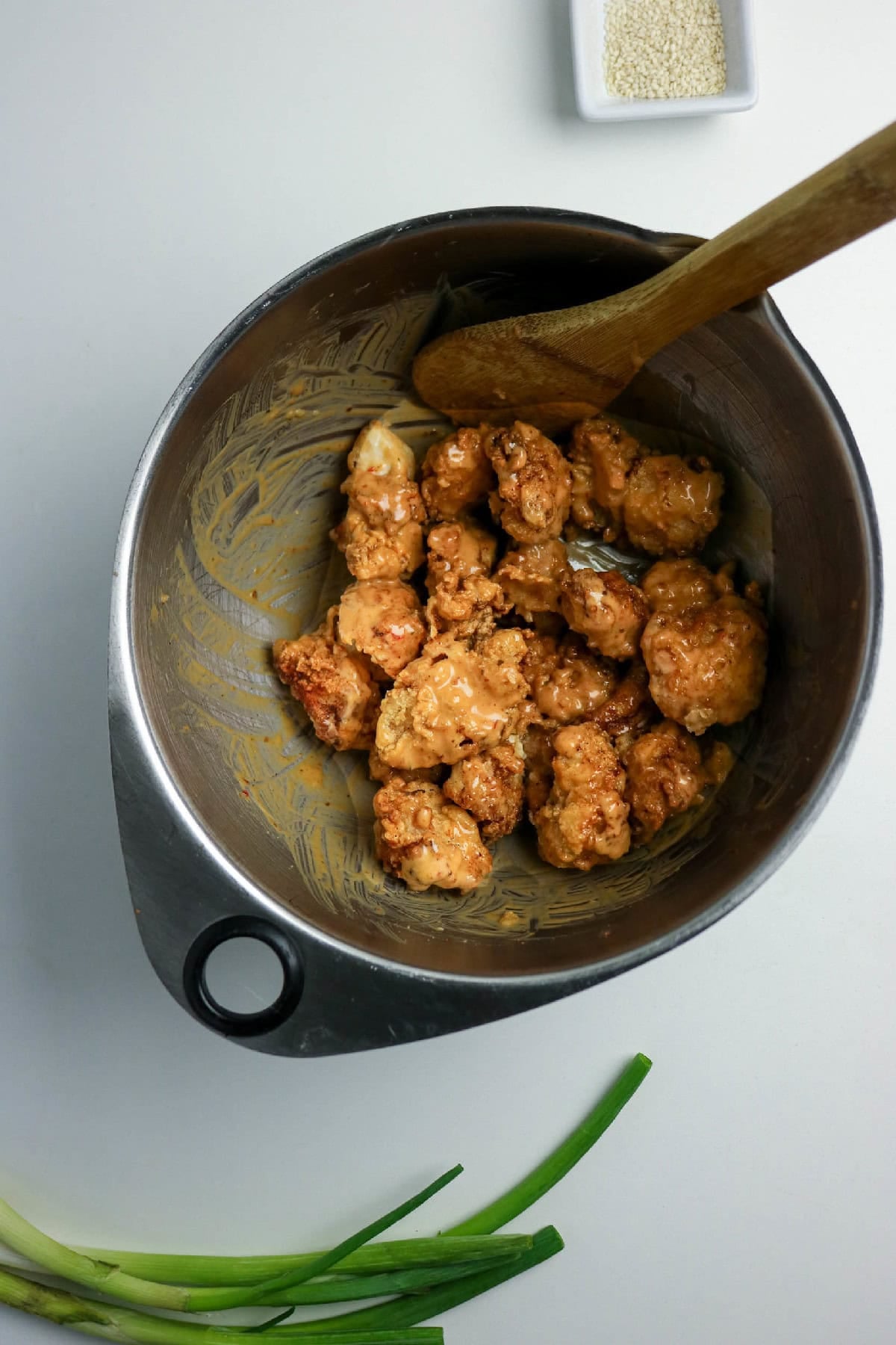 Crispy chicken pieces evenly coated in bang bang sauce.