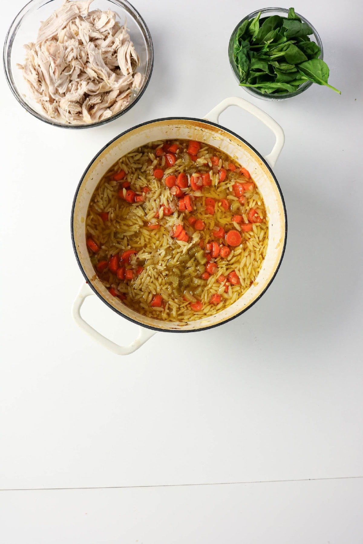 Shredded chicken and fresh spinach added to the orzo soup.