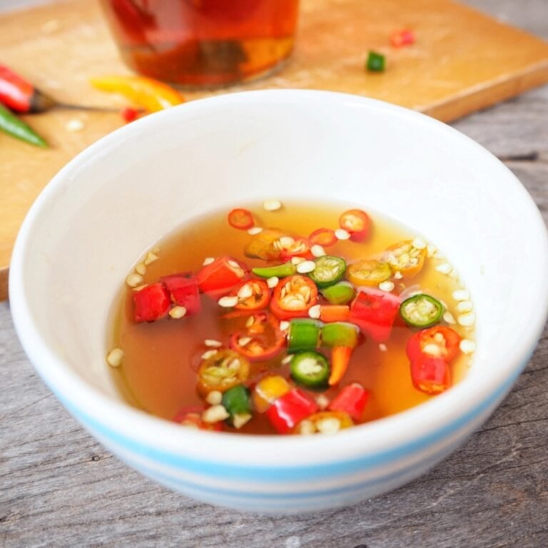 Bowl of fish sauce topped with sliced red and green chilies.