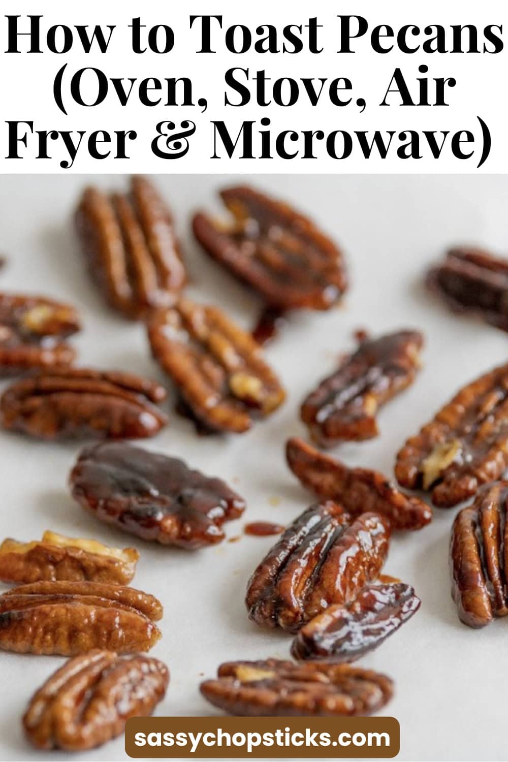 Toasted pecans spread across a baking sheet showing how to toast pecans in the oven, on the stove, in an air fryer, or in the microwave.