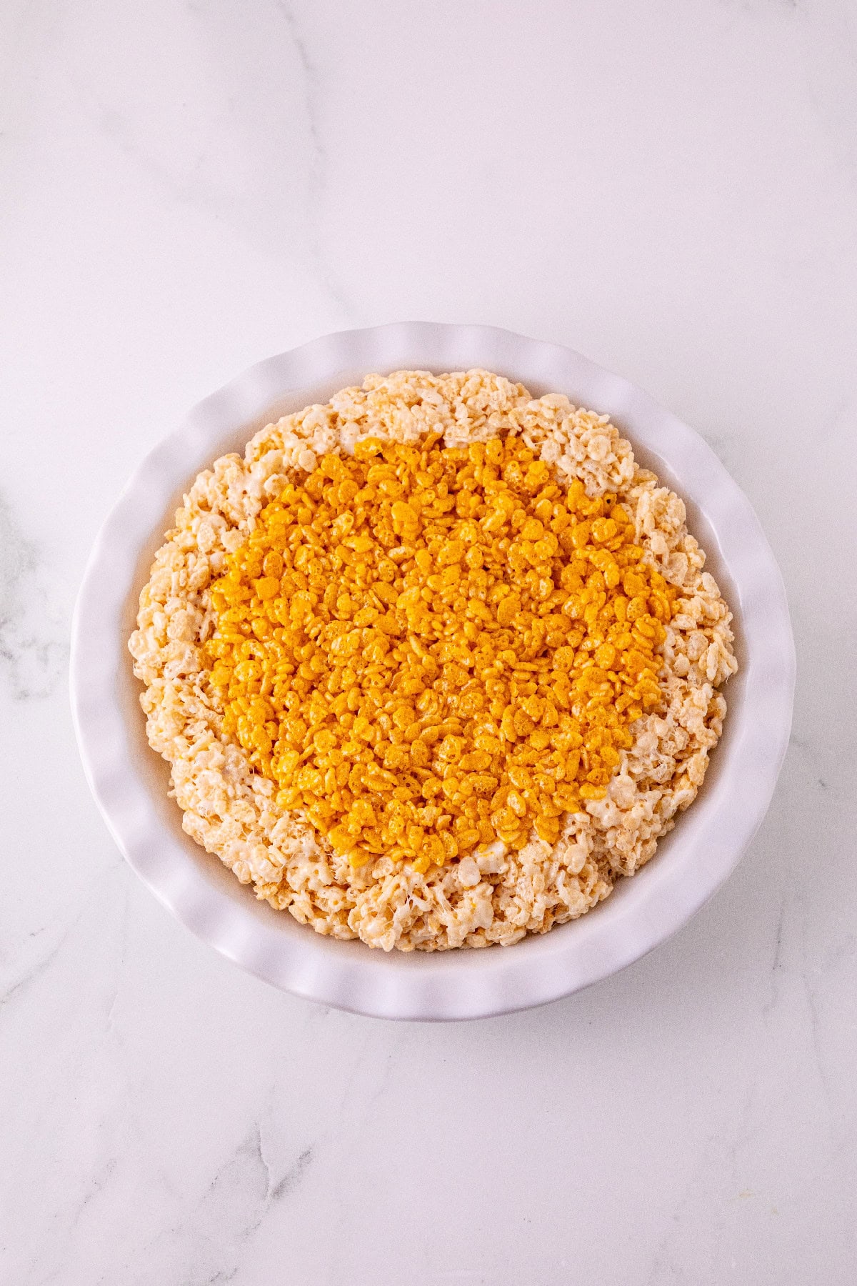 Pumpkin spice Rice Krispie mixture pressed inside the prepared crust.
