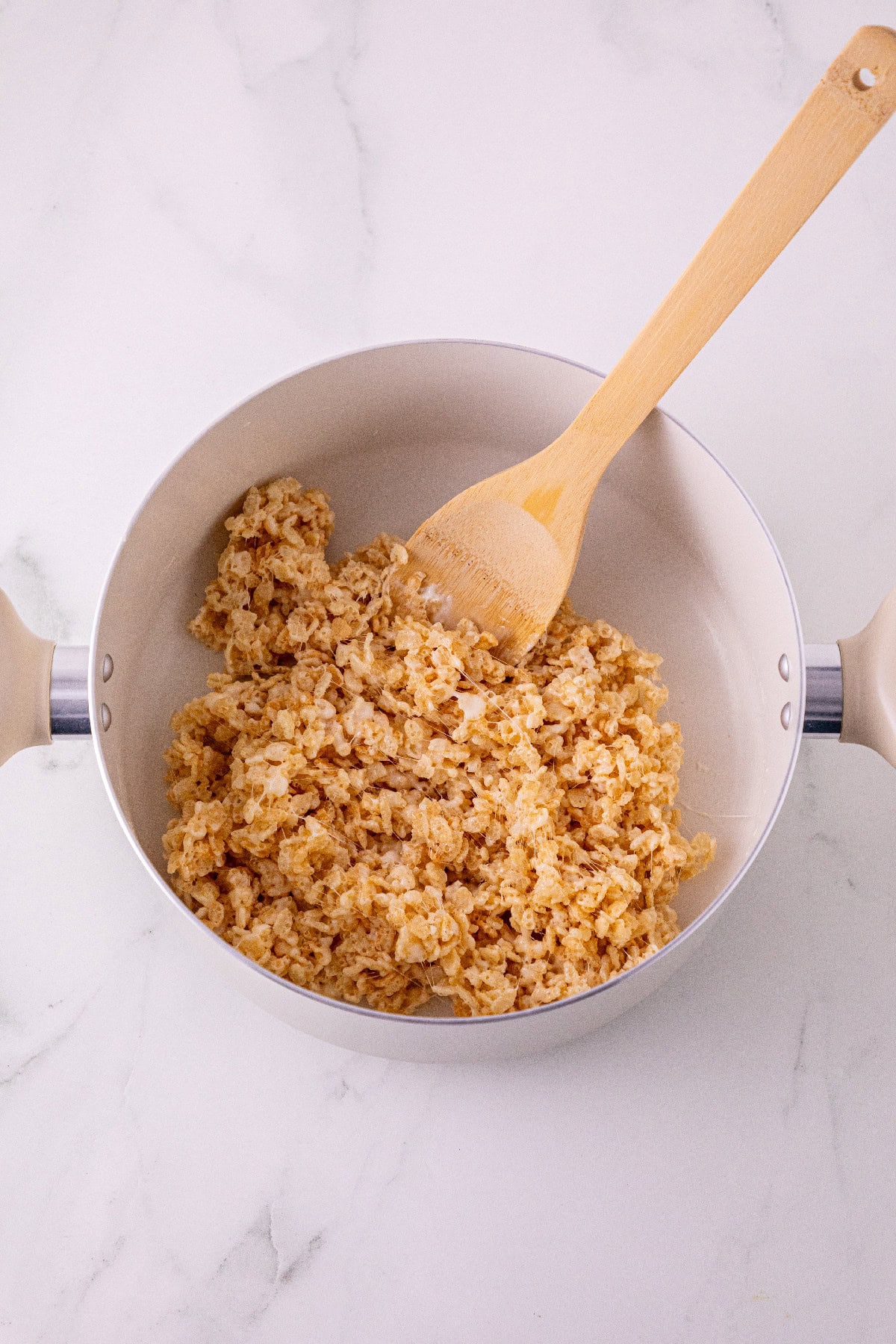 Rice Krispies cereal mixed with melted marshmallows in a saucepan.