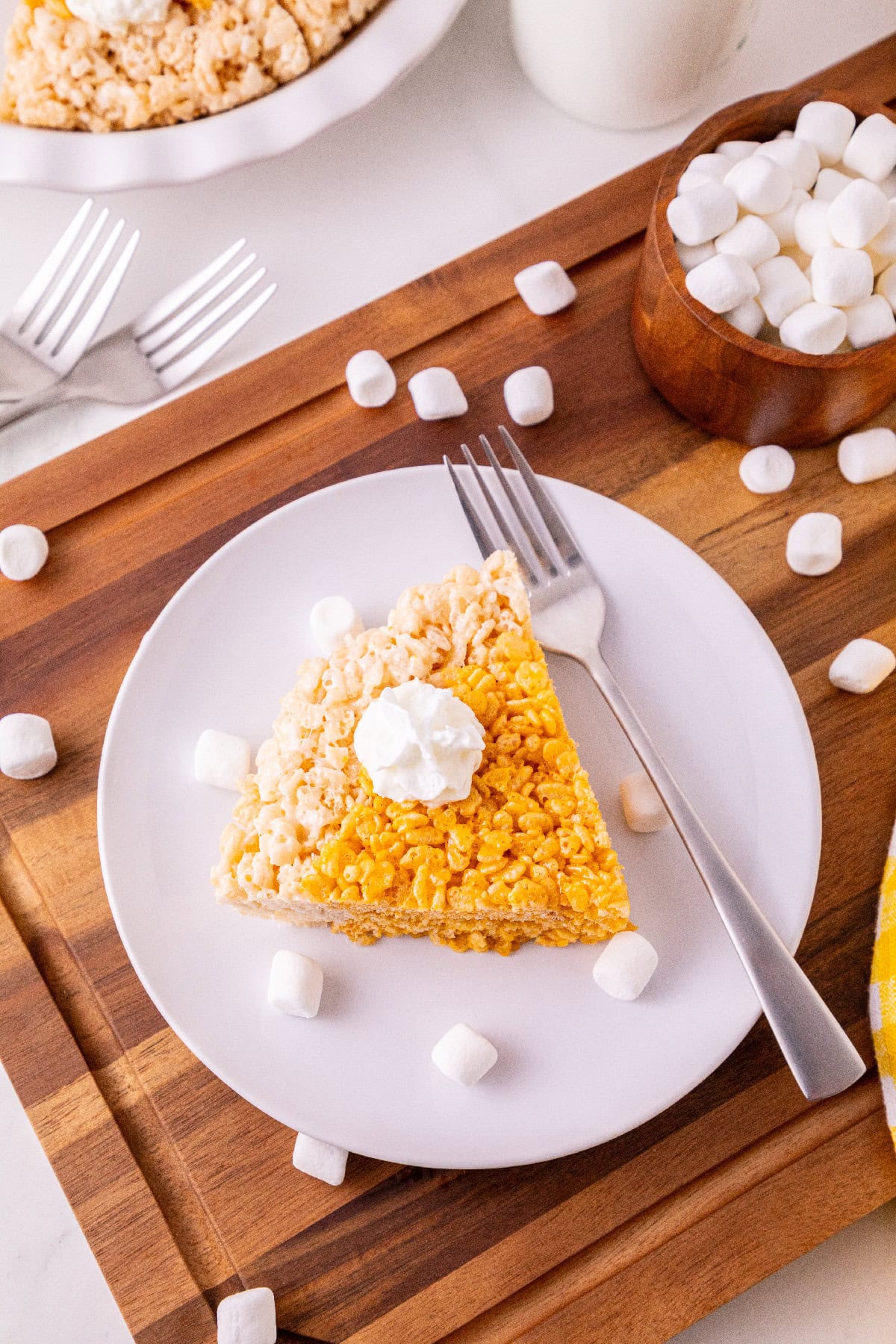 Overhead view of a pumpkin spice Rice Krispie treat pie slice topped with whipped cream.