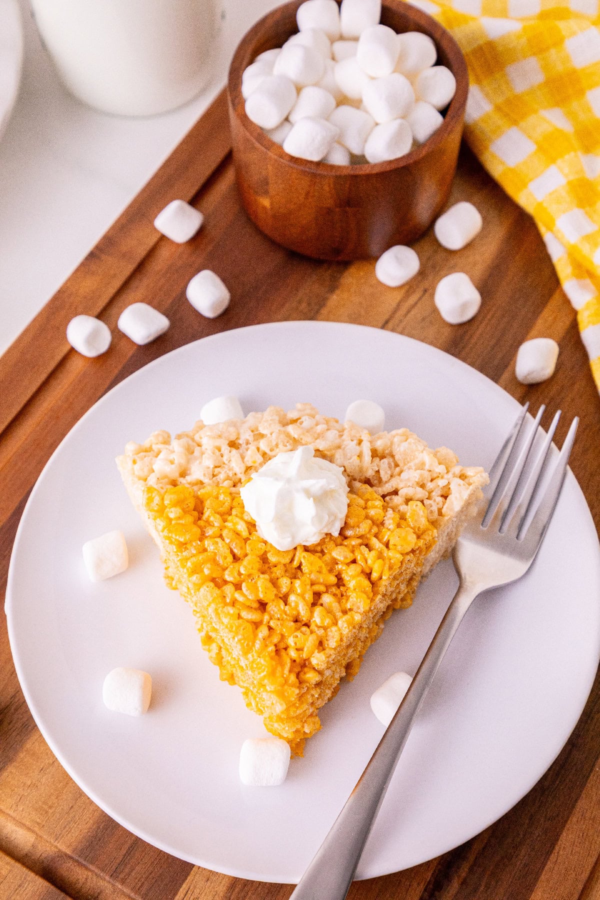 Pumpkin-shaped Rice Krispie treat pie slice with an orange filling and cereal crust.