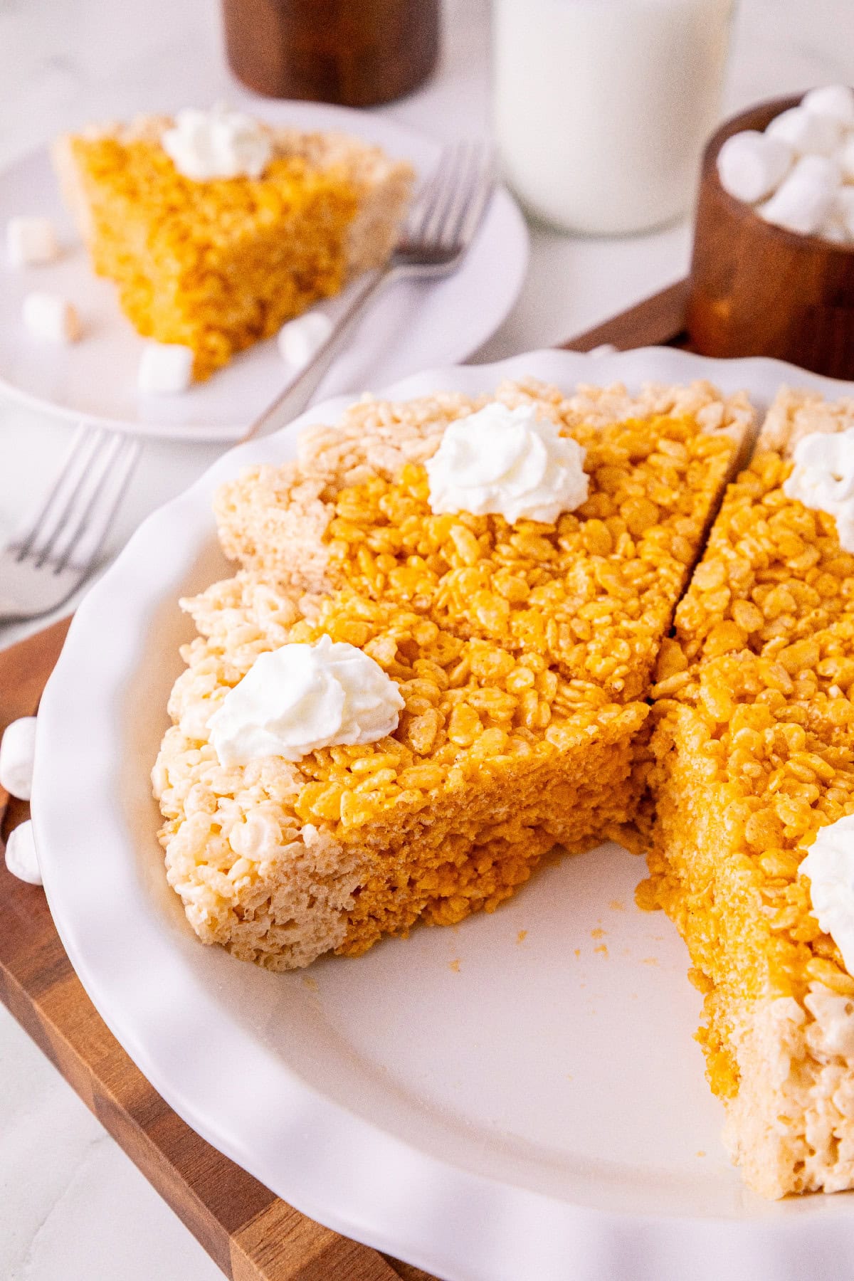Pumpkin spice Rice Krispie treat pie cut into slices and topped with whipped cream.