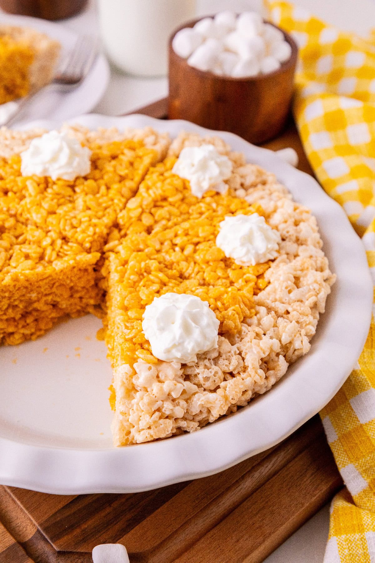Close-up of pumpkin spice Rice Krispie pie slices with a cereal crust and whipped cream.