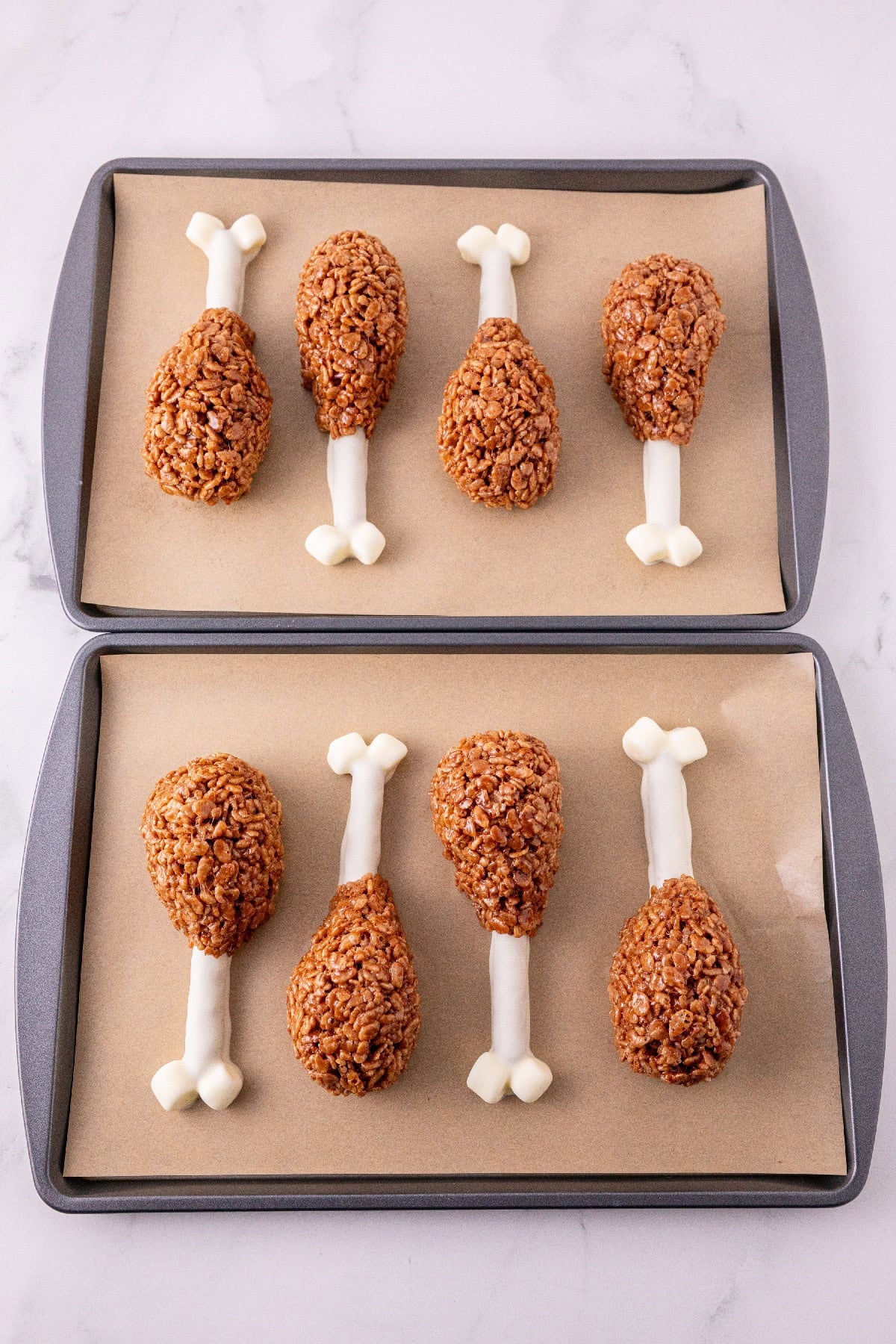 Chocolate Rice Krispie mixture shaped around white pretzel bones.