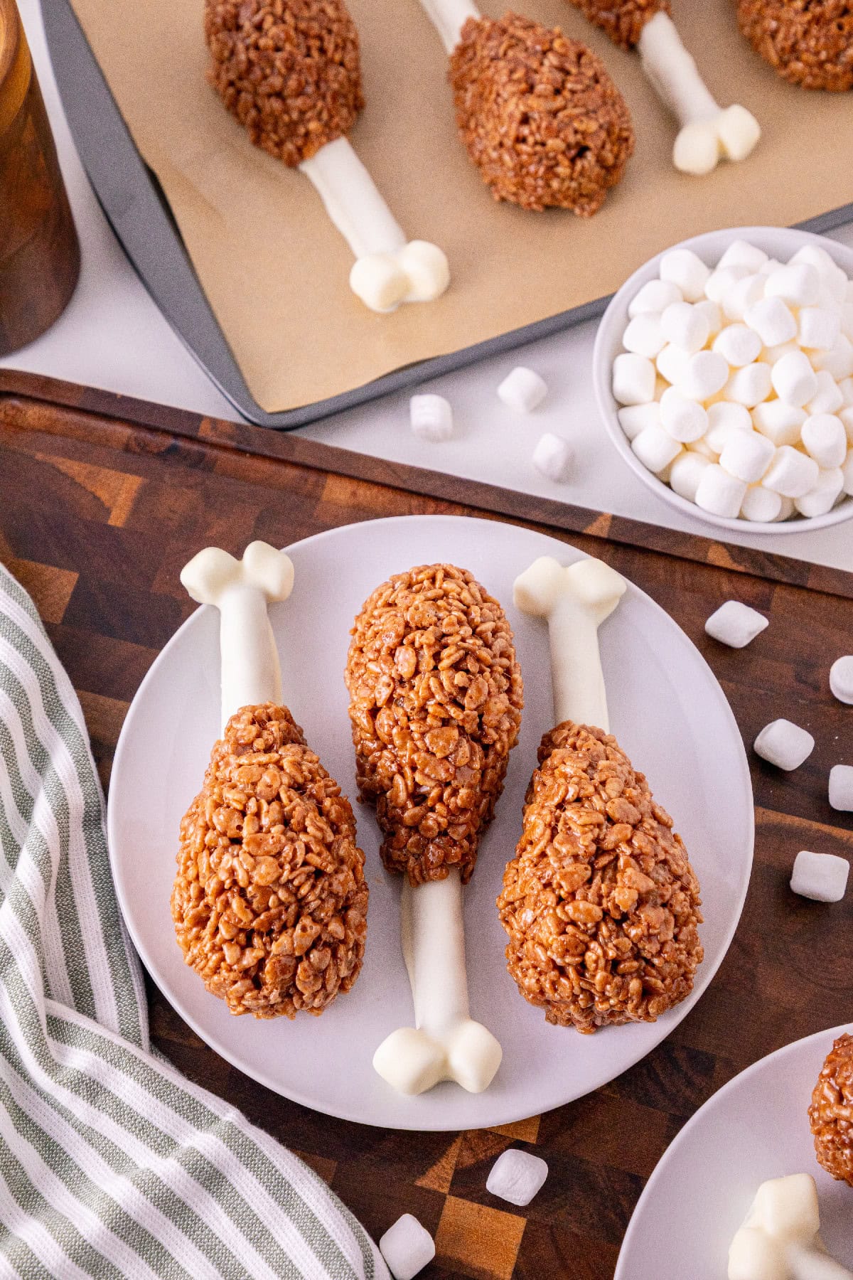 Rice Krispie turkey leg treats displayed on a plate with mini marshmallows.