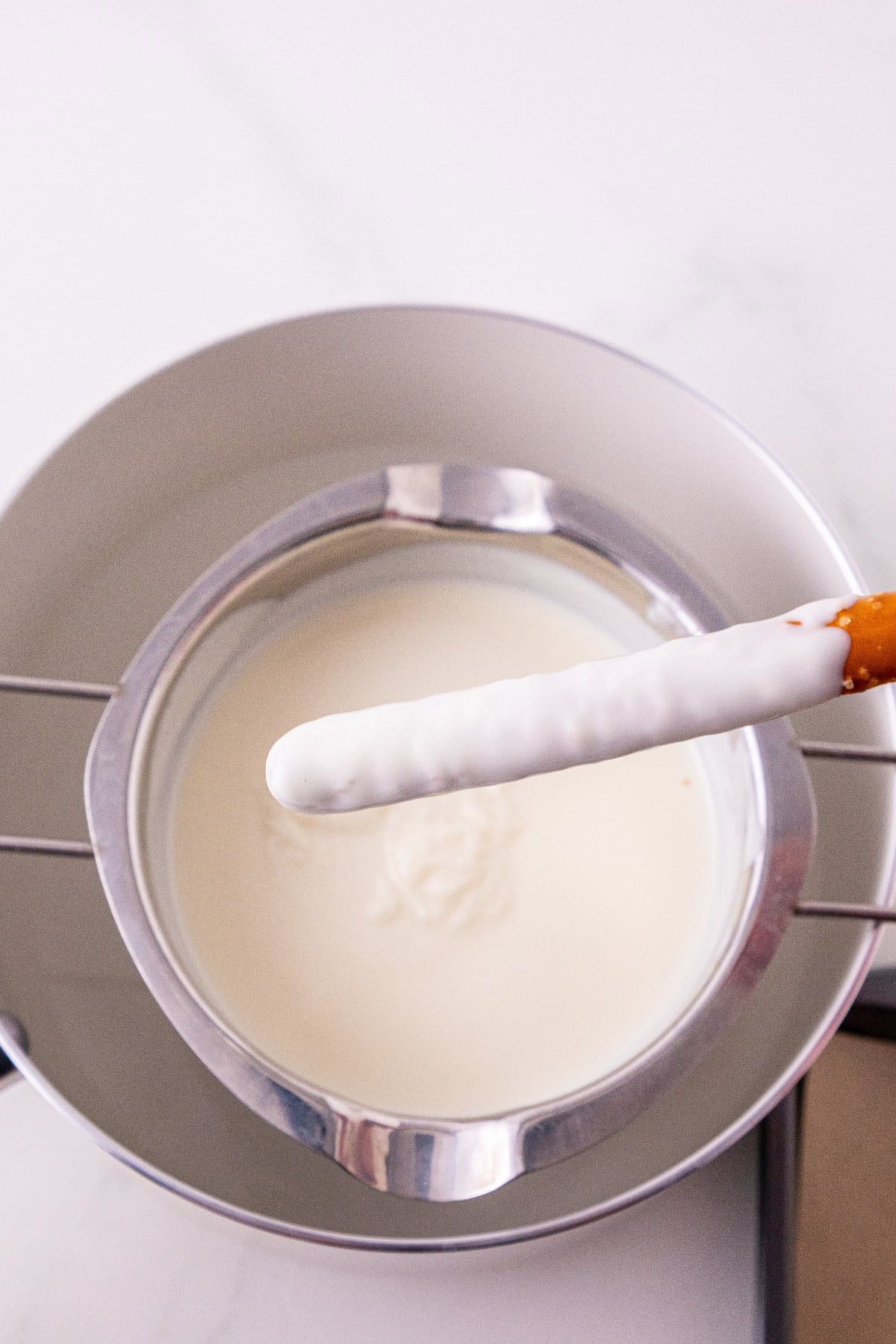 Pretzel rod dipped in melted white wafers.