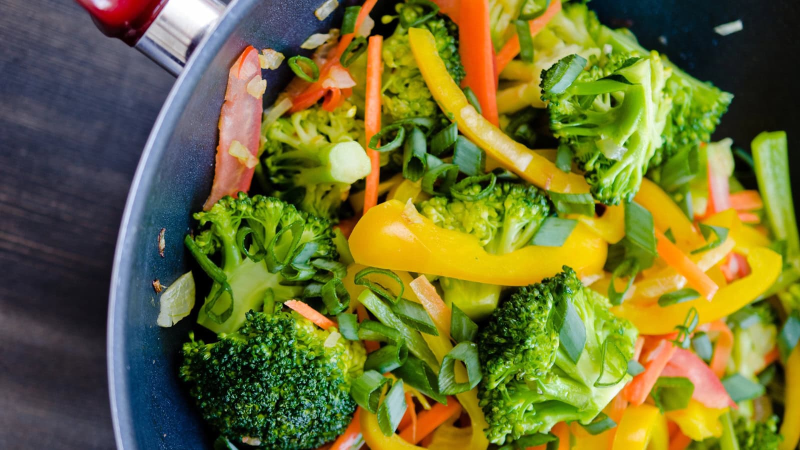 Sautéed broccoli with colorful peppers, carrots, and green onions.