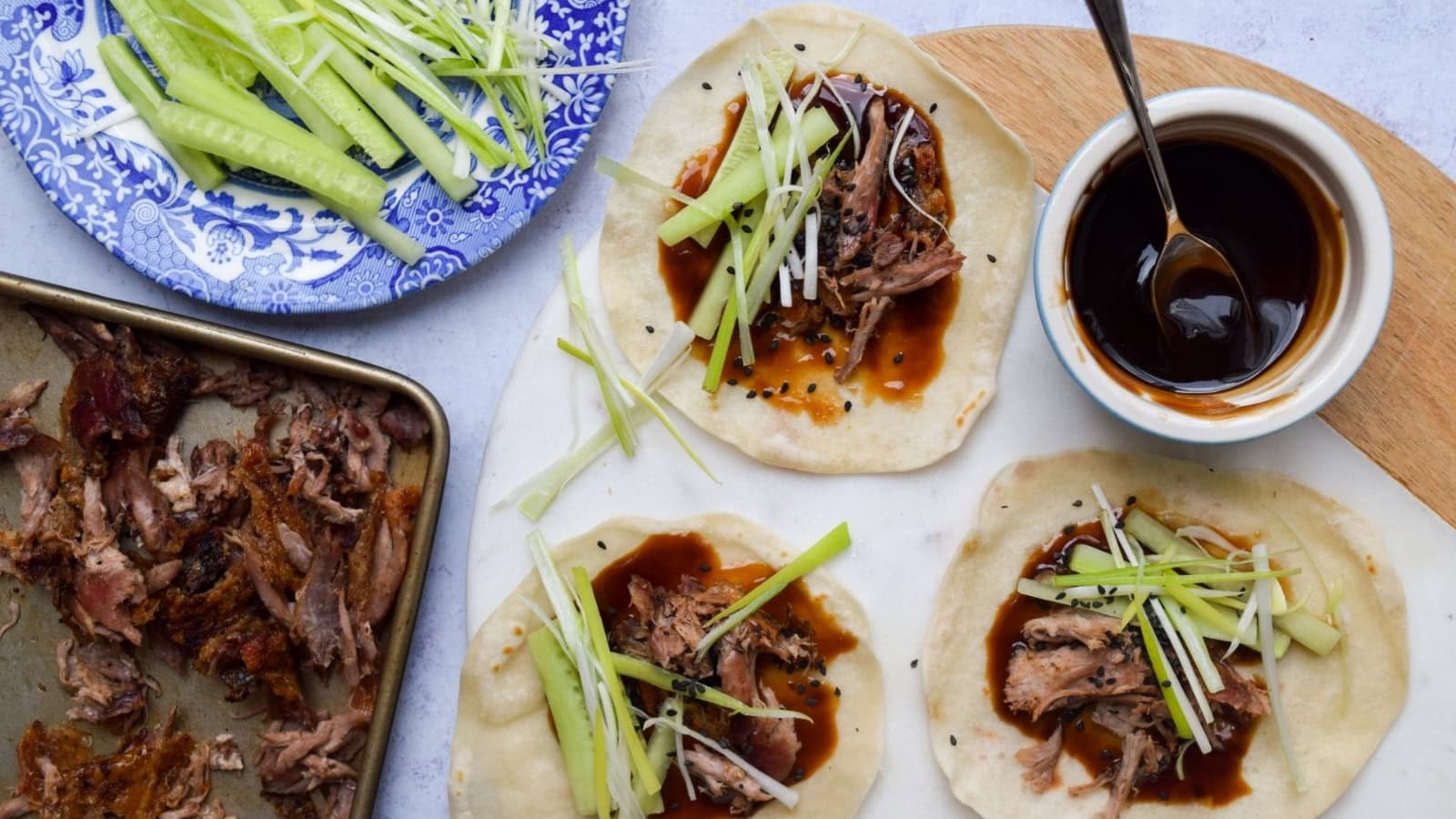 Hoisin-glazed duck wrapped in thin pancakes with fresh vegetables.