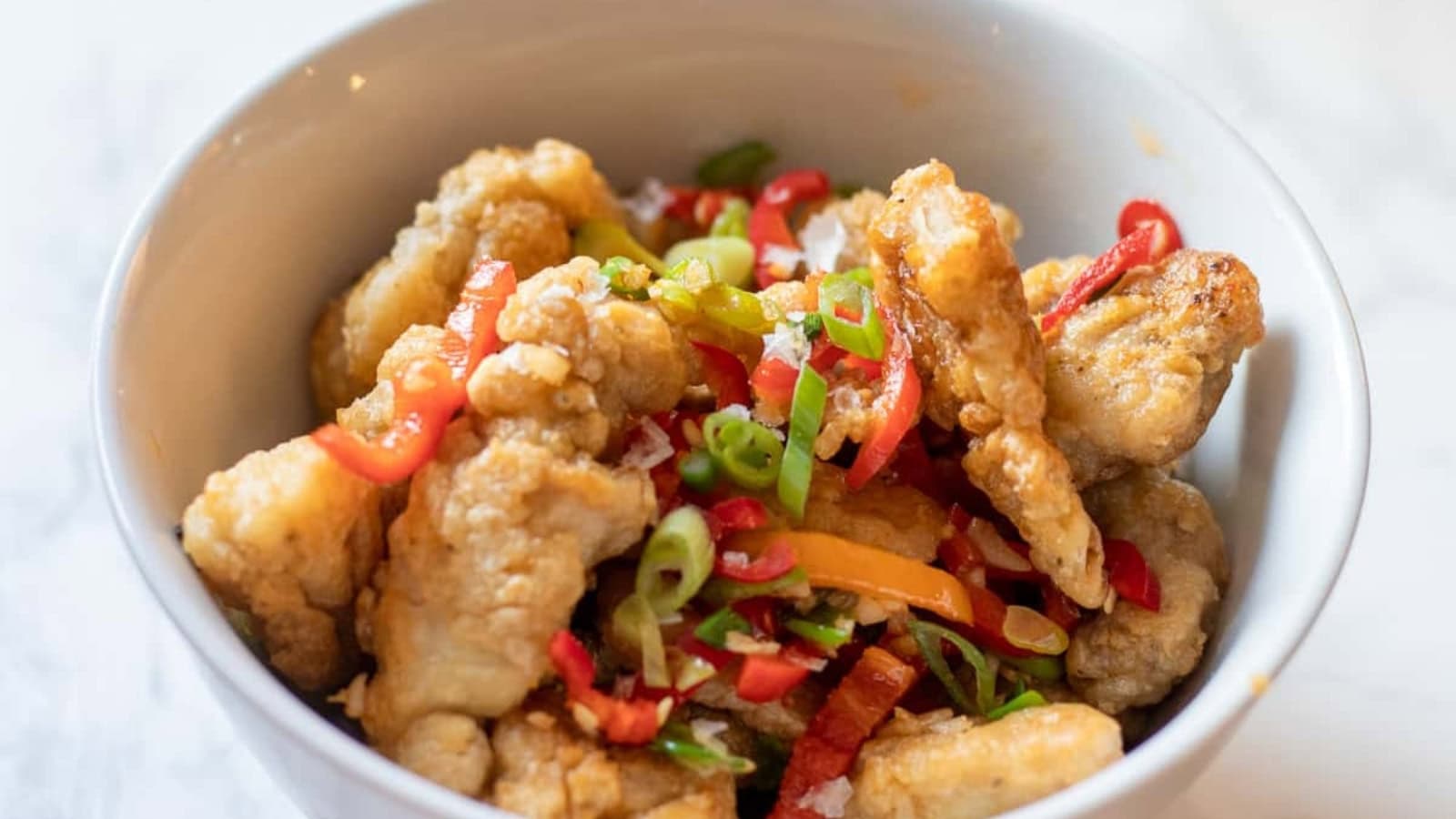 Crispy salt and pepper chicken pieces seasoned with aromatics and spices.