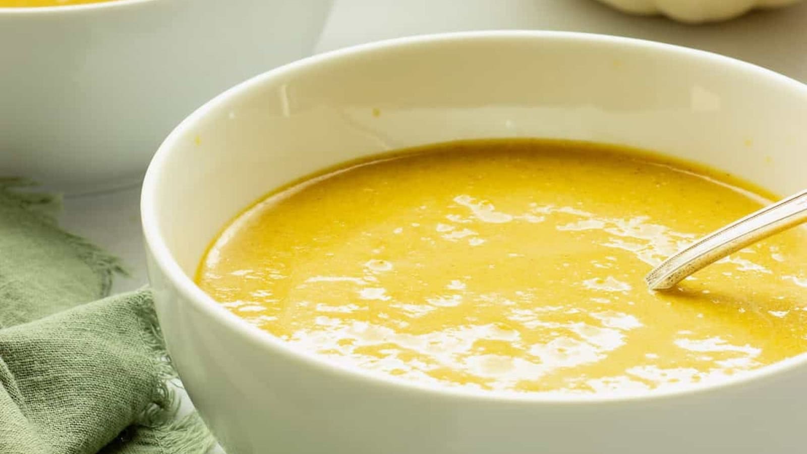 Creamy spiced pumpkin bisque served in small appetizer glasses.