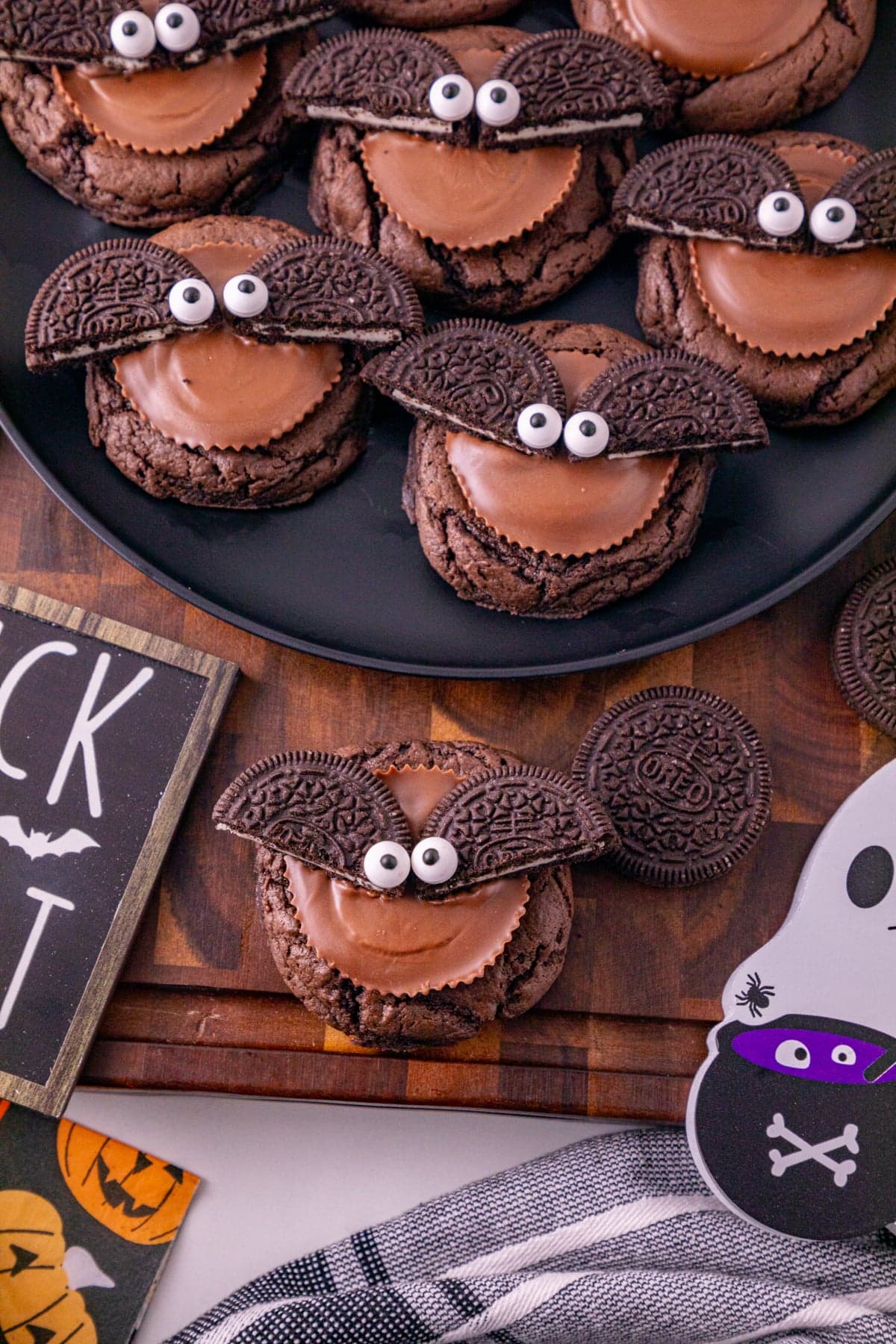 Close-up of decorated Oreo bat cookies with chocolate cookies, peanut butter cups, Oreo wings, and candy eyes.