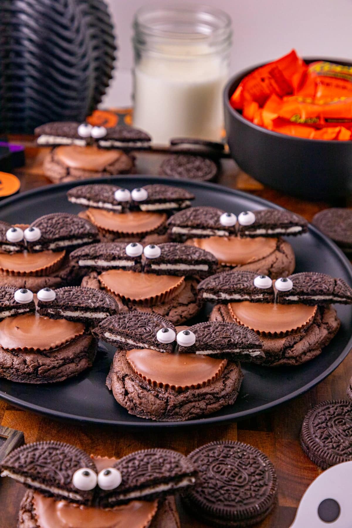 Close-up of Oreo bat cookies with peanut butter cup centers, Oreo wings, and candy eyes on a Halloween display.