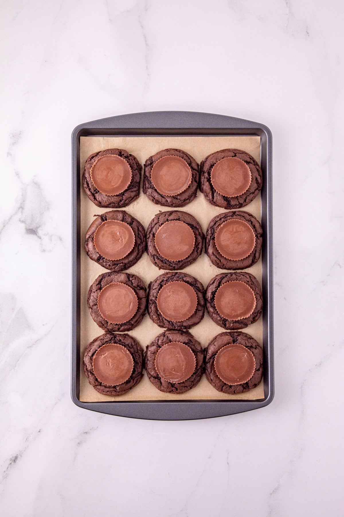 Reese’s peanut butter cups pressed into the centers of freshly baked chocolate cookies.