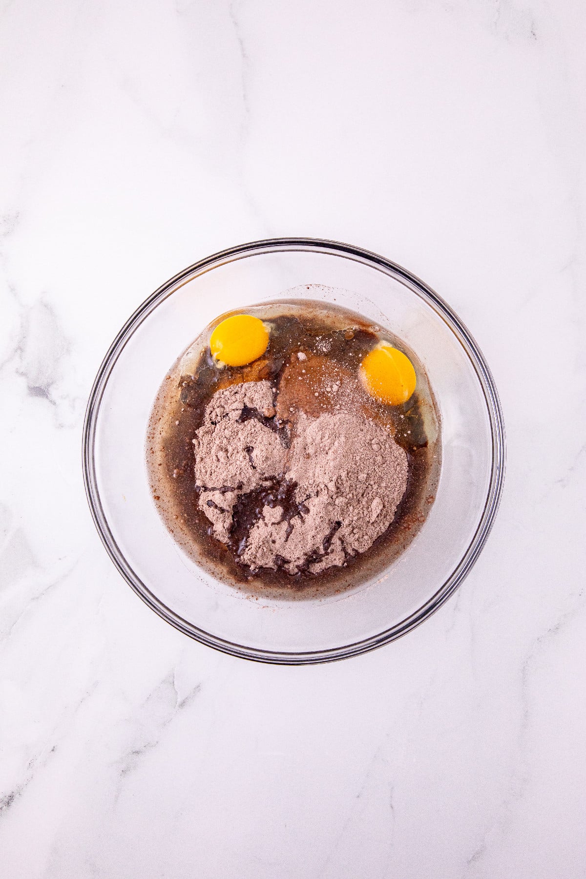 Chocolate cake mix, oil, and eggs in a bowl for Halloween cake mix cookies.