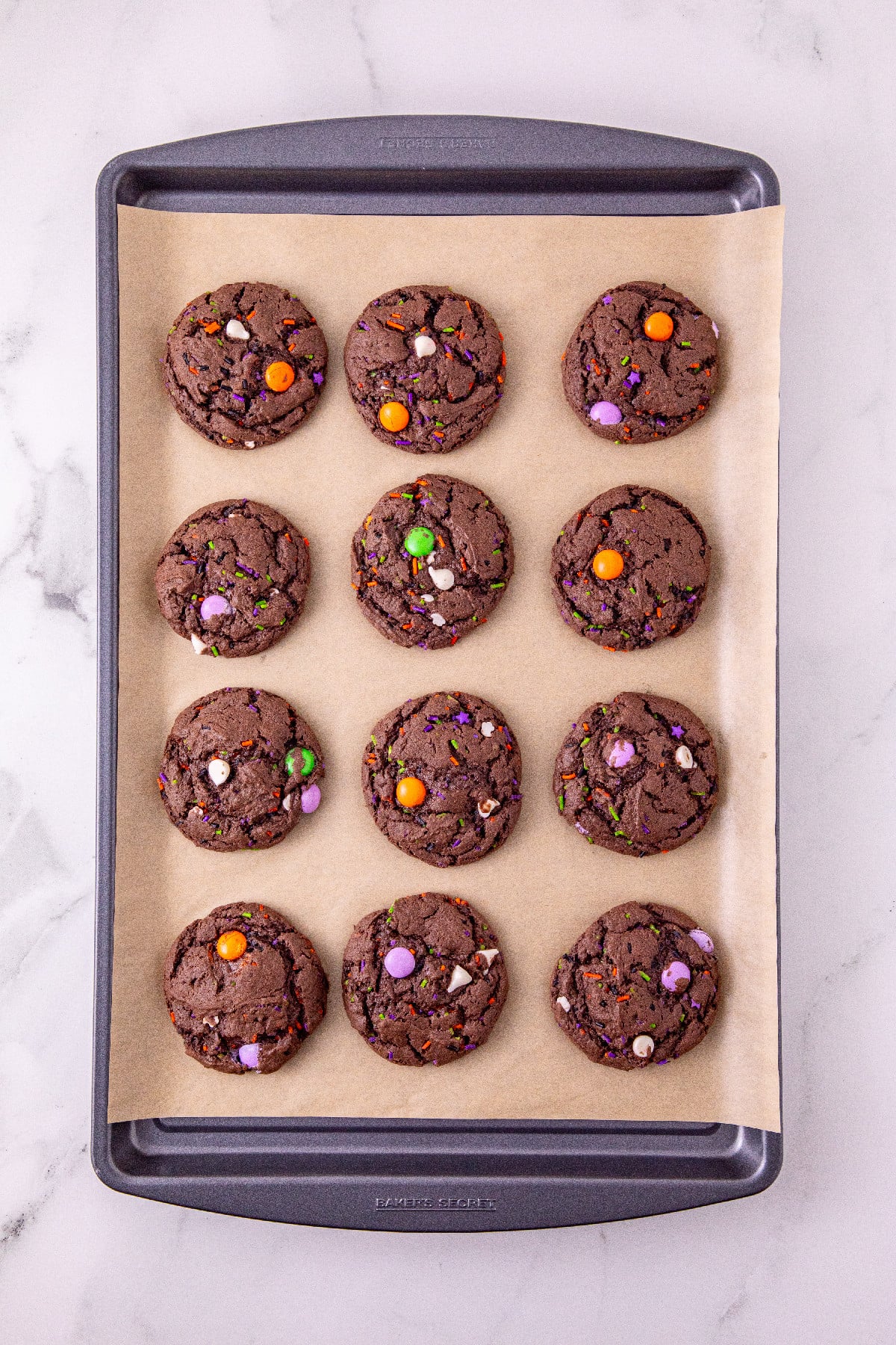 Baked Halloween cake mix cookies on a parchment-lined baking sheet.