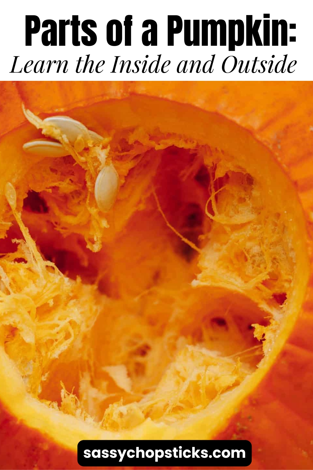 The inside of a cut pumpkin showing orange flesh, stringy pulp, and pumpkin seeds.